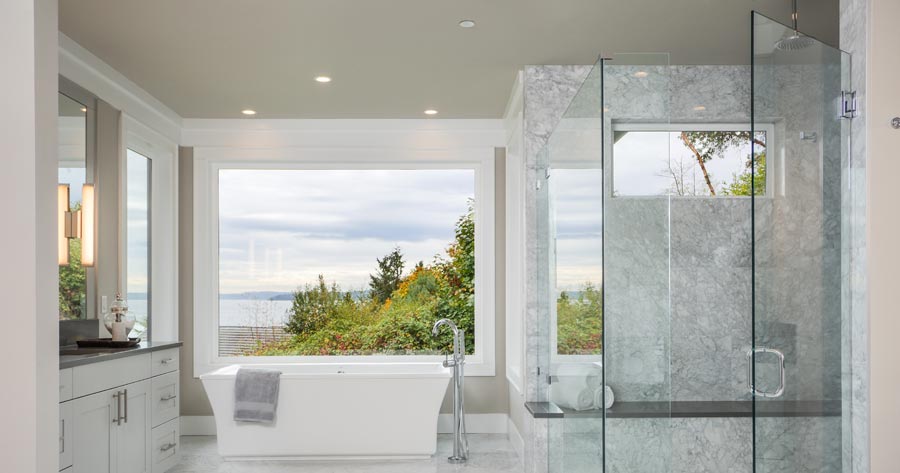 Modern stone tiled bathroom with large glass shower