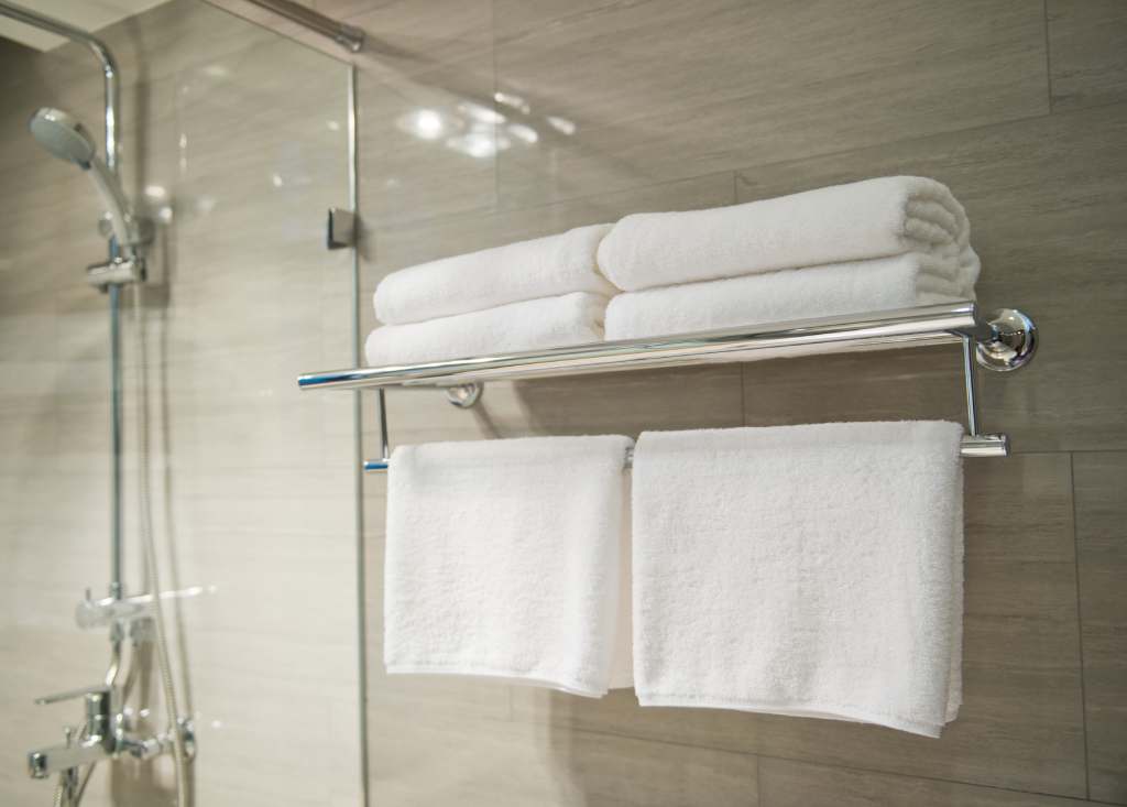 A towel rack next to a glass hotel shower door