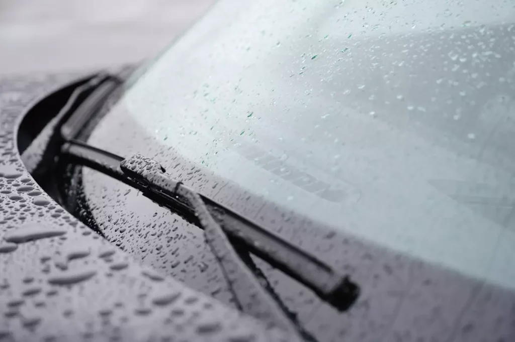 A closeup of a windshield wiper on a wet windshield.
