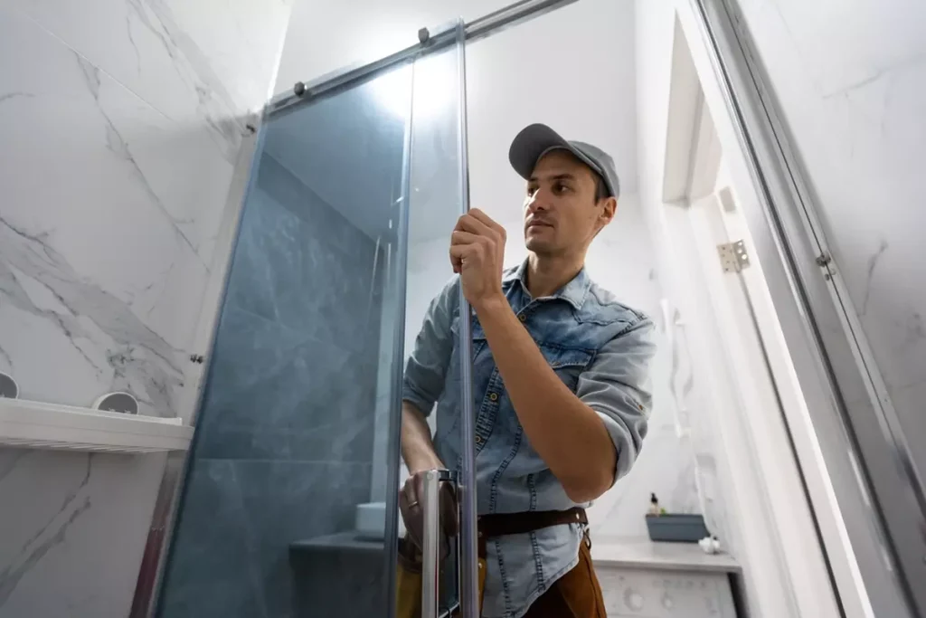 workers-installing-glass-door-shower-enclosure A worker installing a glass shower door.