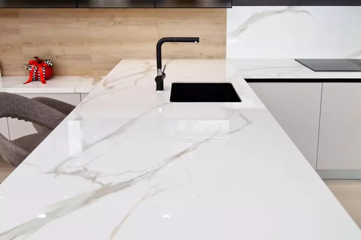 A long white granite countertop with a sink.
